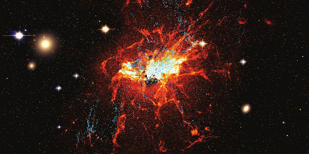 Unge kuglehobe (blå prikker) og røde kolde gasser omkring den centrale store galakse i Perseus galaksehoben